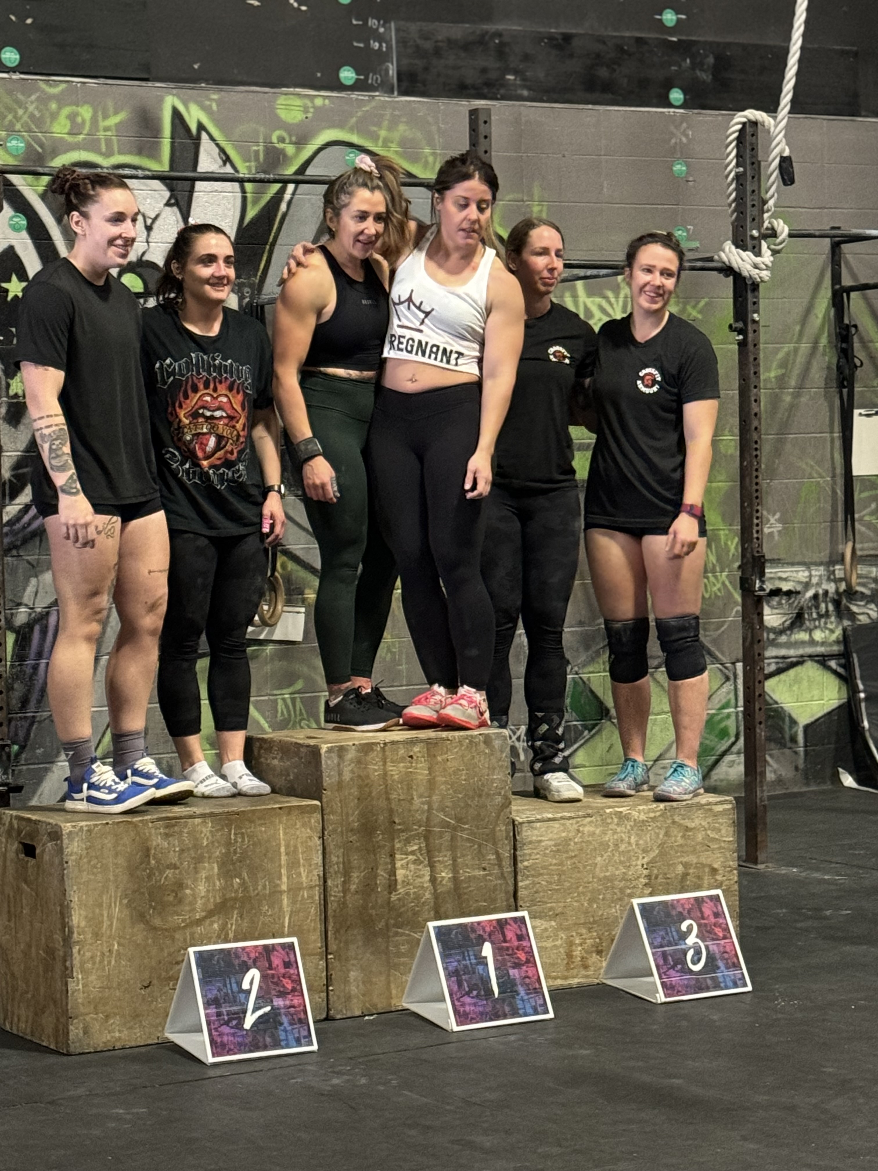Regnant Strength members celebrating on the podium after a competition